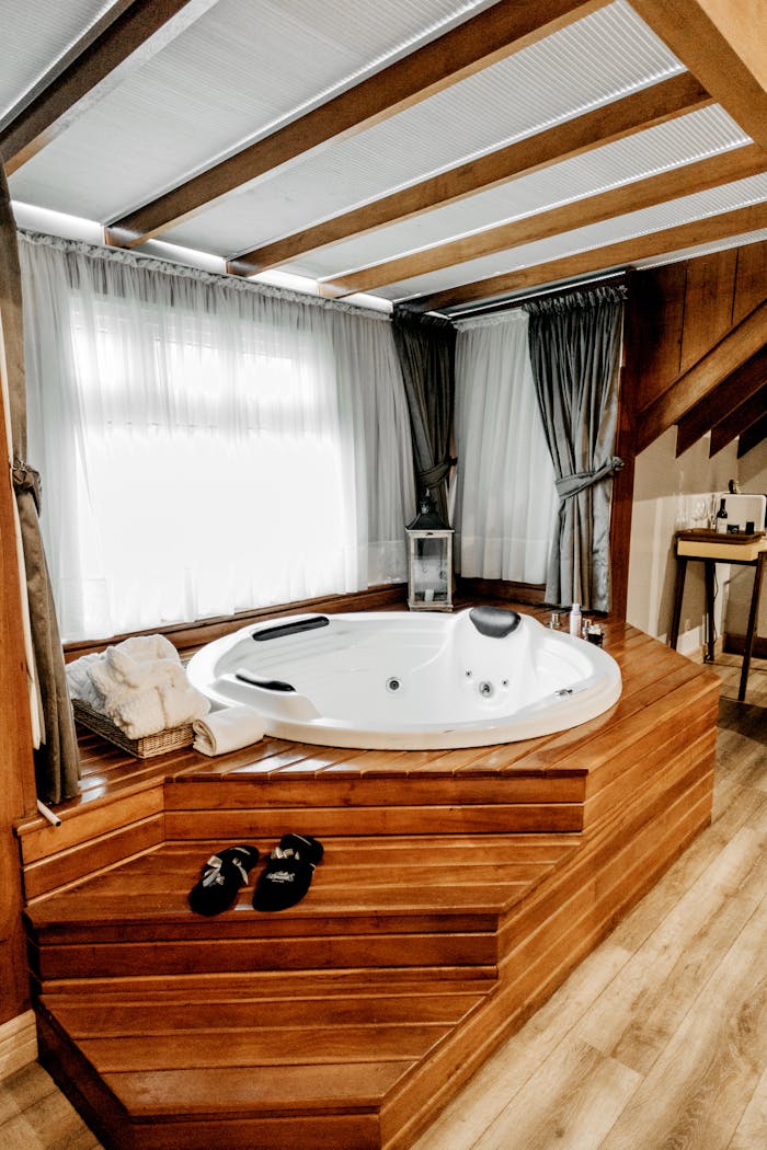 our-services-2 Elegant indoor spa featuring a modern wooden bathtub with luxurious amenities, perfect for relaxation.